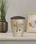 Preview: Exclusive pet urn for cats in beige with a velvety surface and brown lid, adorned with a pad printed motif of a cat on a swing under a flowering tree – A loving and comforting memorial site.